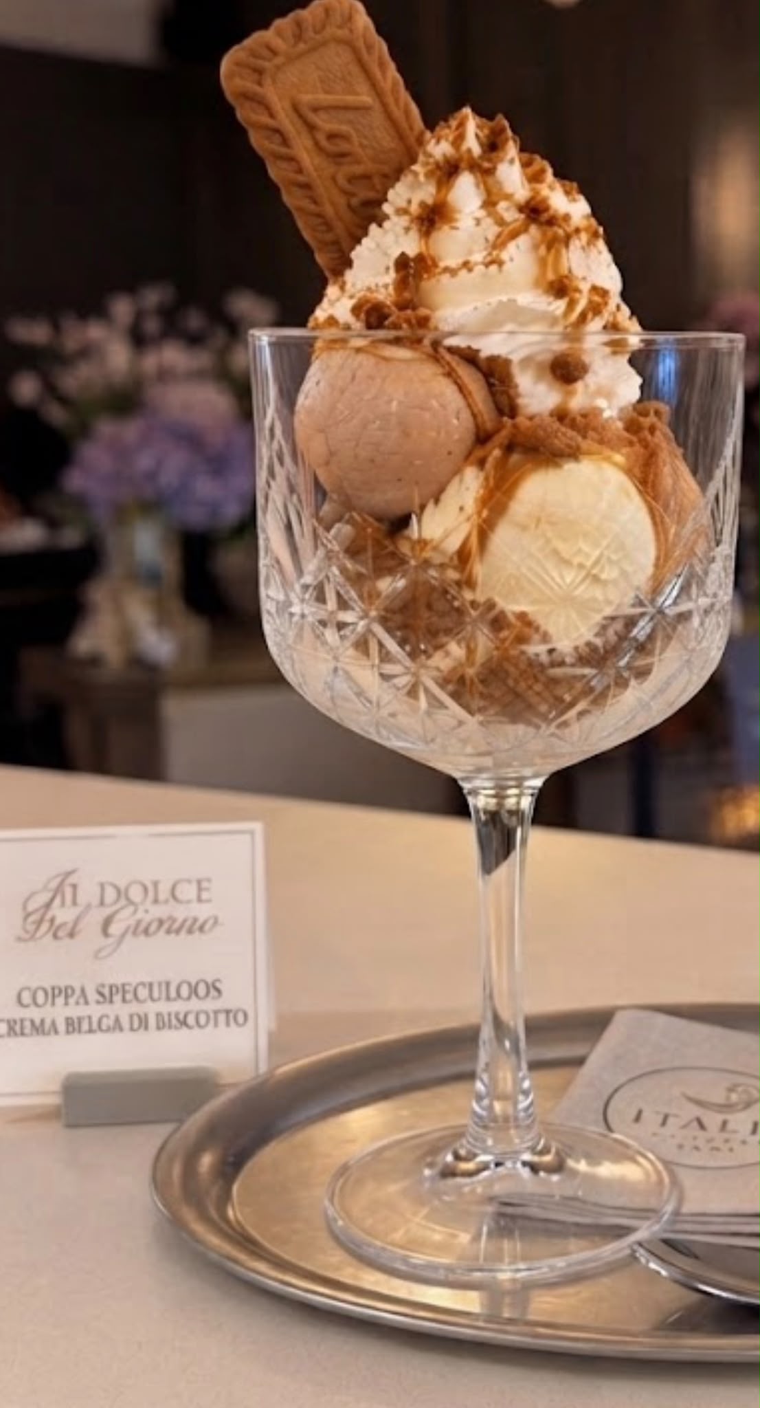 Coppa Speculoos met vanille- en speculoosijs, slagroom, karamel en een Lotus-koekje in een kristallen coupe
